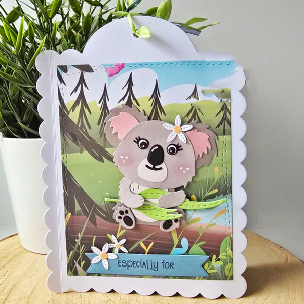 Greeting card with a koala design on a wooden surface with a plant in the background
