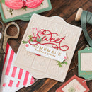 Decorative card with 'Sweet Homemade Holiday Treats' text on a wooden surface with crafting items.