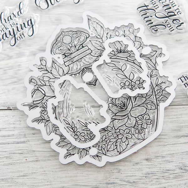 Clear stamp set with floral and nature-themed designs on a wooden surface.