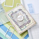 Decorative 'Thank You' card on a crafting surface with stamps and paper.