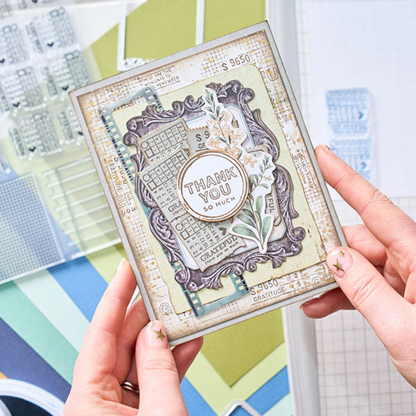 Hand holding a decorative card with 'Thank you so much' text against a colorful background.