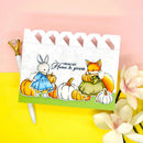 Card with cartoon rabbit and fox holding pumpkins on a pink and yellow background