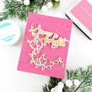 Pink card with 'Merry & Bright' text and Christmas lights design, surrounded by festive decorations on a white background.