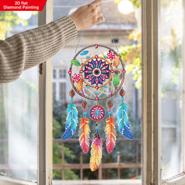 Colorful dreamcatcher hanging by a window with a blurred outdoor background
