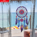 Colorful dreamcatcher hanging by a window with a beach view