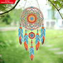 Colorful dreamcatcher with feathers hanging outdoors