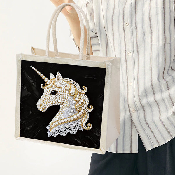 Tote bag with a decorative unicorn design held by a person wearing a striped shirt.