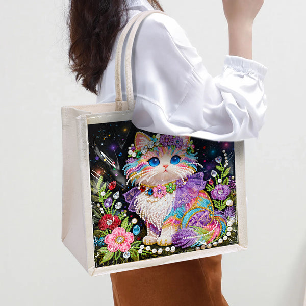 Tote bag with a colorful cat design held by a person wearing a white shirt.