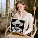 Woman holding a tote bag with a decorative design of a woman wearing a hat and jewelry.