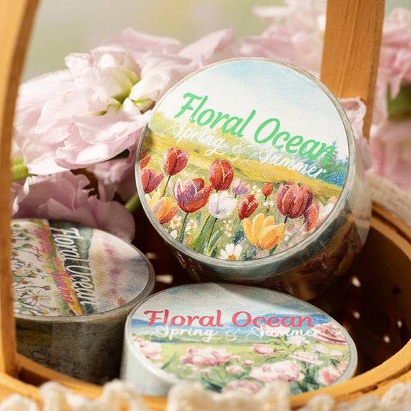 Three containers labeled 'Floral Ocean' with floral designs on lids, placed in a woven basket with pink flowers.