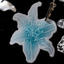 Translucent blue flower-shaped keychain on a black background