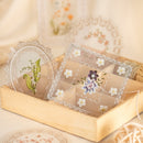 Decorative lace doilies with floral designs in a wooden box.