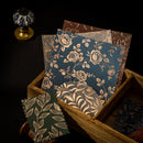 Set of floral-patterned cards in a wooden box on a dark background