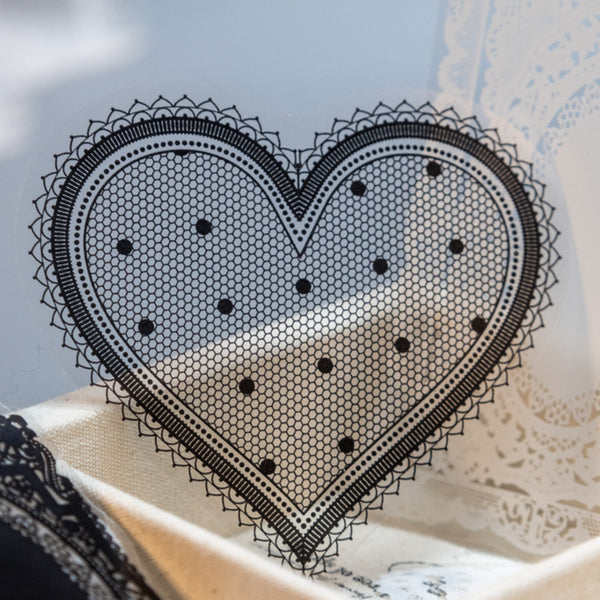 Black lace heart-shaped doily on a textured surface