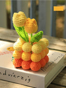 Crocheted fruit sculpture on a book with a blurred background