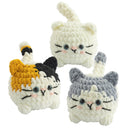 Three crochet cat toys in different colors on a white background