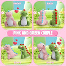 Crocheted pink and green dinosaur couple on a display card with front, back, and side views.