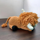 Knitted lion toy on a wooden surface with a white background