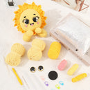 Crocheted sun-shaped toy with yarn balls and crafting tools on a white surface