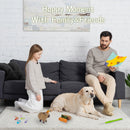Man and child with a dog on a rug, surrounded by toys, in a room with a gray couch and white brick wall.