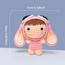 Crocheted doll with pink outfit and bunny ears, shown with measurements on a light blue background.