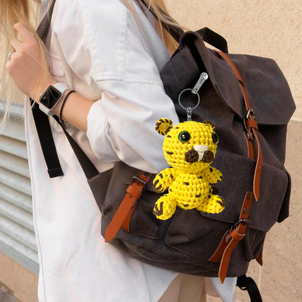 Brown backpack with a yellow crochet tiger keychain attached