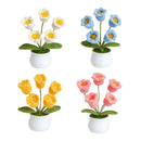 Set of four crocheted flower arrangements in white pots on a white background