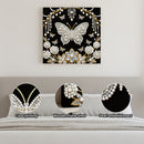 Decorative wall art with butterfly and floral design on a black background, displayed above a sofa.