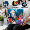 Person holding a diamond painting with underwater scene, showing close-ups of printing quality, frame shedding, and pearl embellishment.