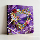 Decorative wall art with a heart-shaped frame of beads, flowers, and a butterfly on a purple background.