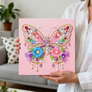 Person holding a pink canvas with a colorful butterfly design made of beads and pearls.