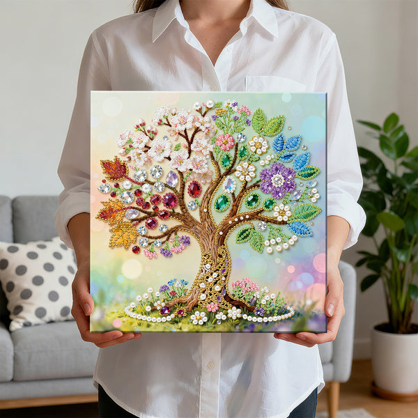Person holding a colorful tree painting with gemstones in a living room setting