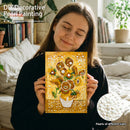 Woman holding a DIY decorative pearl painting of sunflowers in a cozy room.