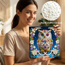 Woman holding a diamond painting kit with an owl design, surrounded by pearls of different sizes.