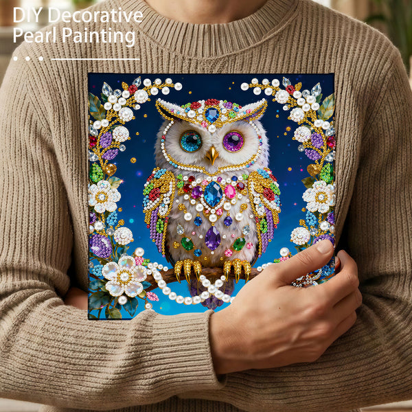 Person holding a completed DIY decorative pearl painting of an owl.