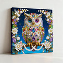 Decorative owl painting with gemstones and flowers on a blue background