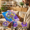 Person holding a DIY decorative pearl painting kit with a living room background