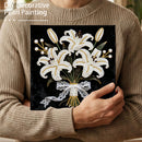 Person holding a completed pearl painting of flowers, wearing a beige sweater.