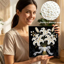 Woman holding a diamond painting with lilies and pearls, inset showing pearls of different sizes.