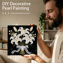 Man holding a completed DIY decorative pearl painting of lilies