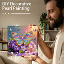 Man holding a completed DIY decorative pearl painting of a colorful butterfly and flowers.