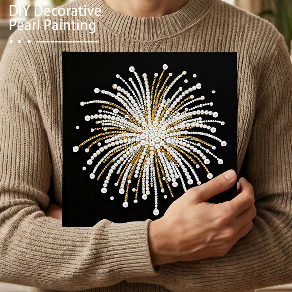 Person holding a completed DIY decorative pearl painting with a black background and white and gold design.