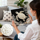 Woman holding a decorative pillow with a turtle design, surrounded by pearls, in a living room setting.