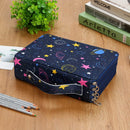 Navy blue cosmetic bag with space-themed design on a wooden surface with books and pencils.