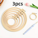 Set of three wooden embroidery hoops with a needle on a white background