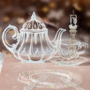 Decorative cutout of a teapot and cup on a textured surface with a blurred background