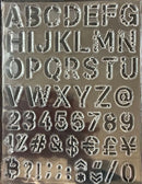 Metallic letter and number stamps on a reflective surface