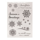 Clear stamp set with snowflake designs and winter-themed text on a beige background