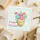 Greeting card with flowers and 'Happy anniversary' text on a wooden surface.