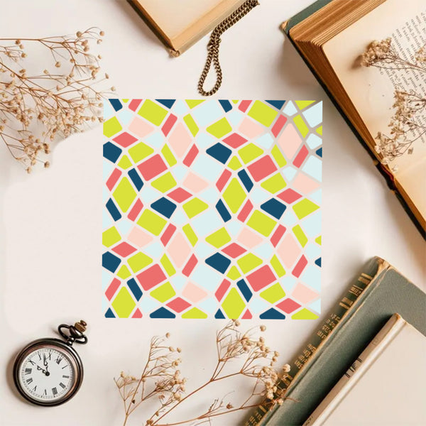 Colorful geometric patterned paper on a surface with books and flowers.